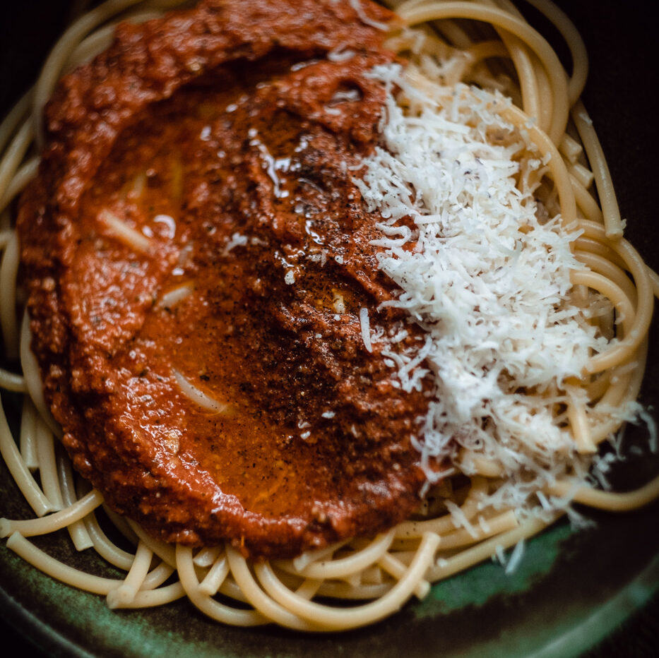 przepis na wegańskie spaghetti bolognese z wegańskim serem, sos pomidorowy z suszonych pomidorów i przecieru pomidorowego, wegańskie mięso z podprażonych nasion słonecznika, makaron spaghetti,